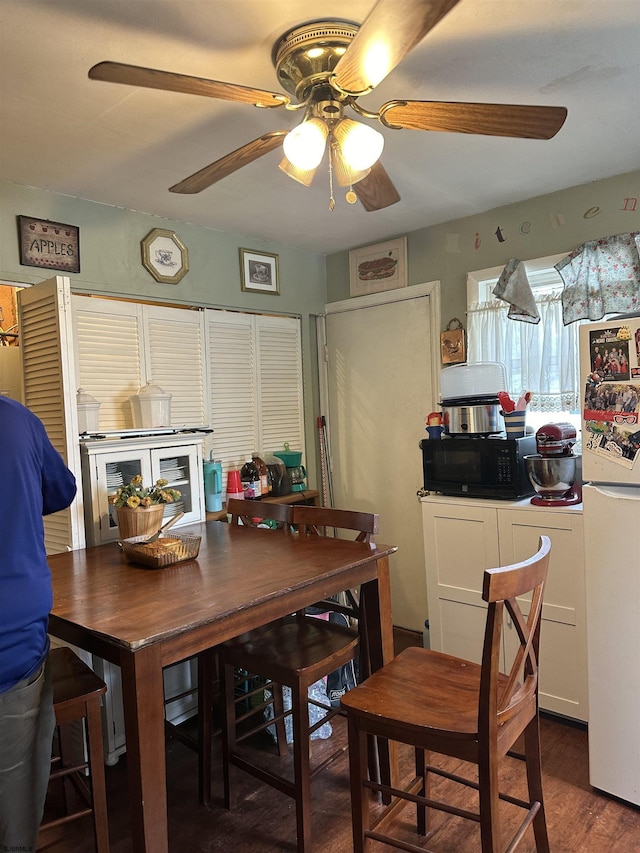 dining space with ceiling fan and wood finished floors