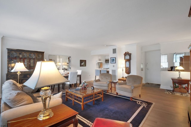 living room featuring wood finished floors, visible vents, and baseboards