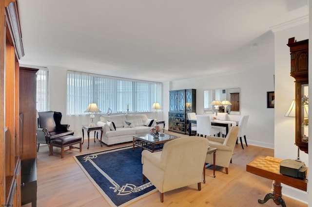 living area with light wood-style flooring and crown molding