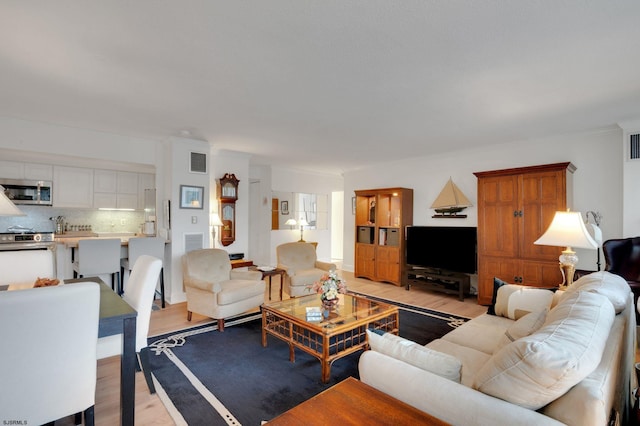 living room featuring visible vents and light wood-style flooring