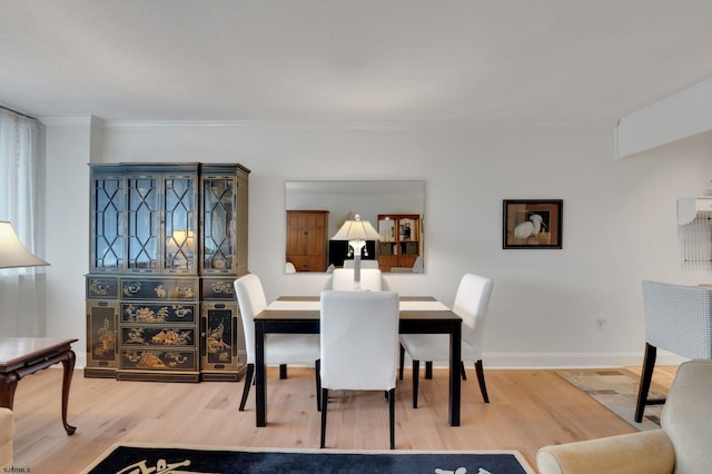 dining room featuring baseboards, wood finished floors, and crown molding