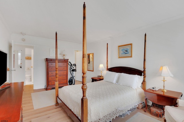 bedroom featuring light wood-style flooring, ensuite bathroom, and ornamental molding