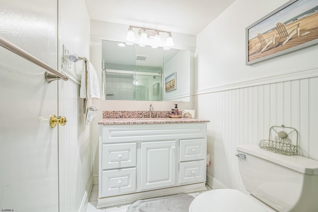 bathroom with visible vents, a wainscoted wall, toilet, an enclosed shower, and vanity