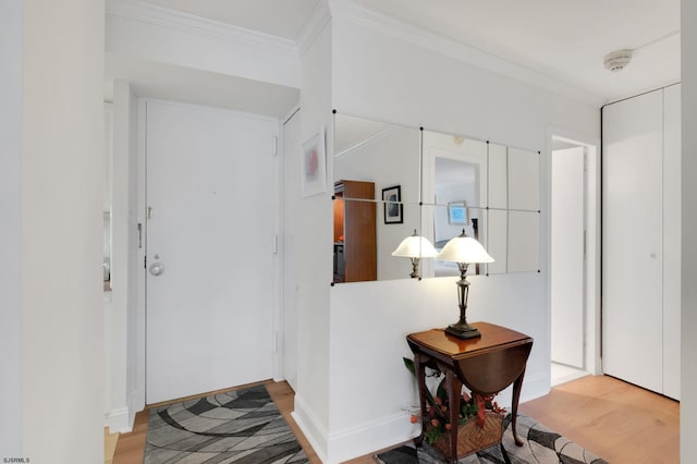 foyer with crown molding and light wood-style floors