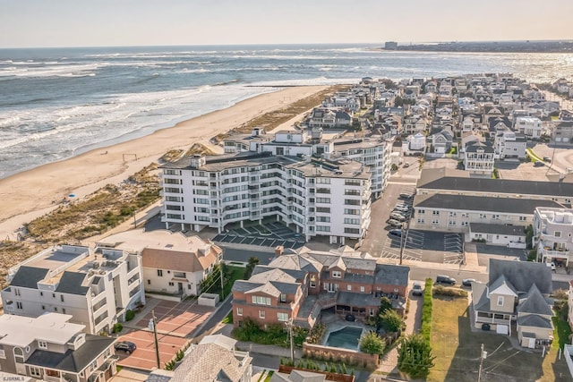 drone / aerial view featuring a beach view and a water view