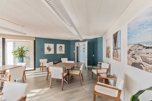 dining space featuring light wood-style floors and baseboards