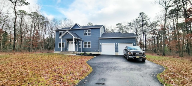 view of front facade with aphalt driveway, an attached garage, and a front yard