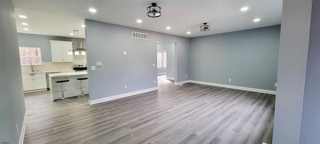 living area featuring recessed lighting, visible vents, baseboards, and wood finished floors