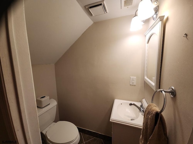 bathroom with visible vents, toilet, vaulted ceiling, tile patterned floors, and vanity