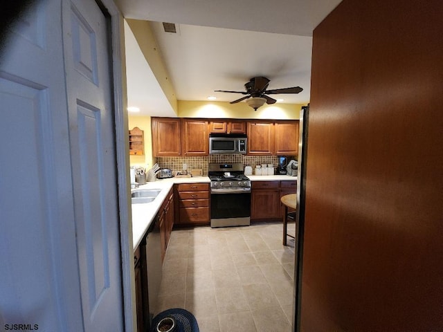 kitchen with visible vents, backsplash, light countertops, brown cabinets, and appliances with stainless steel finishes