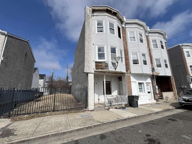 multi unit property featuring a fenced front yard and stucco siding