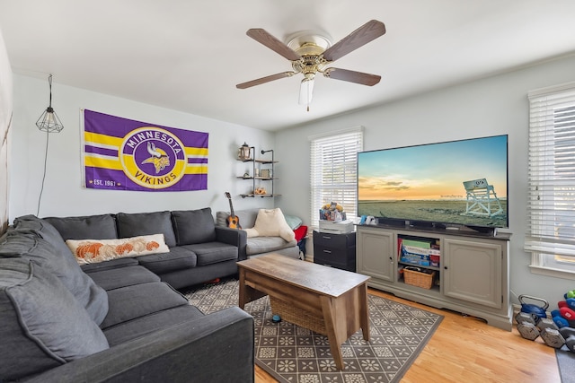 living area featuring light wood-style flooring and a ceiling fan