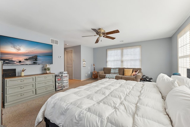 bedroom with ceiling fan, visible vents, and light carpet