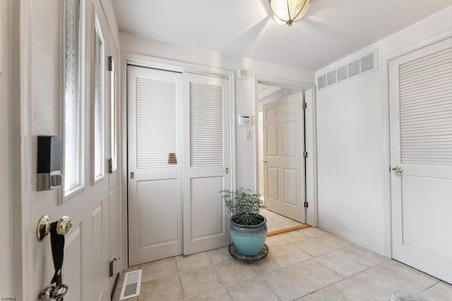 entryway featuring light tile patterned floors and visible vents