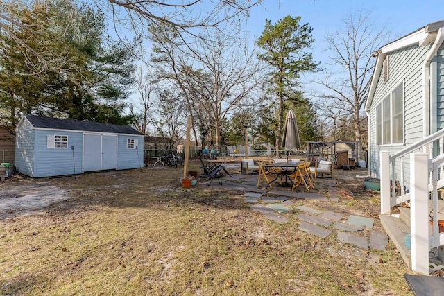 view of yard with an outbuilding, a patio area, and a storage shed