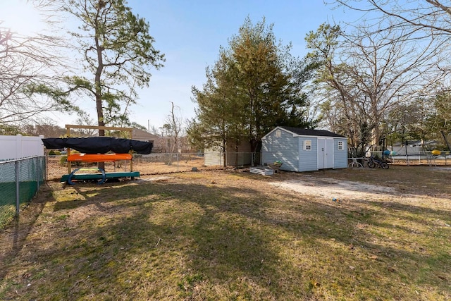 view of yard with a shed, an outdoor structure, and a fenced backyard