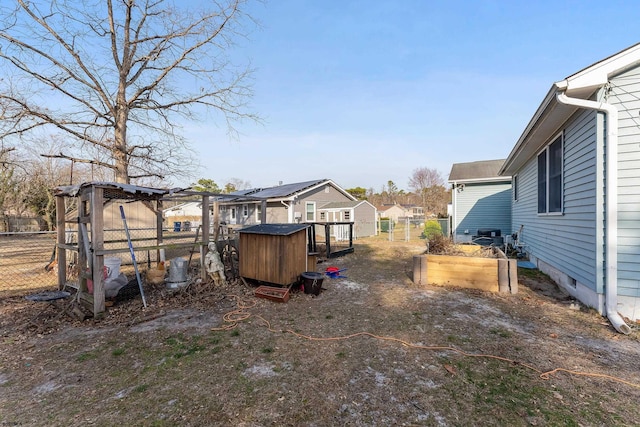 view of yard featuring a residential view, an outbuilding, exterior structure, and fence