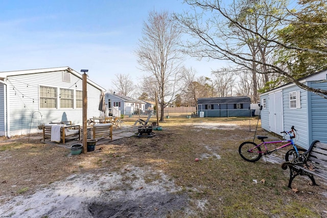 view of yard with an outbuilding, a storage unit, and fence