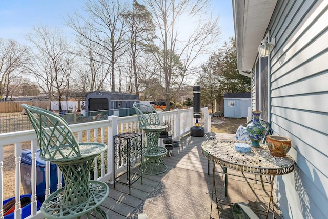 view of patio / terrace with a storage unit, an outdoor structure, and fence