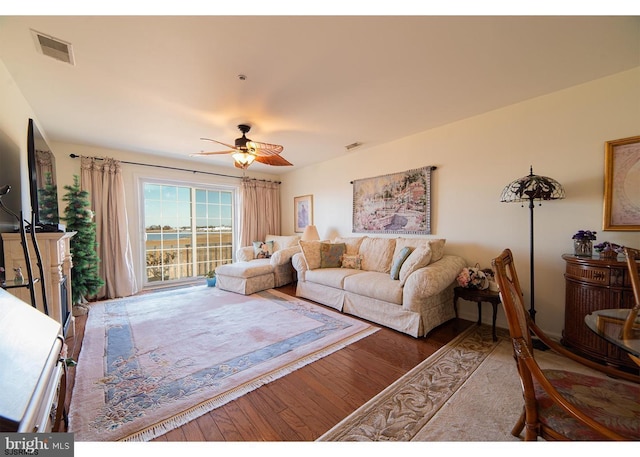 living area featuring visible vents, ceiling fan, and wood finished floors