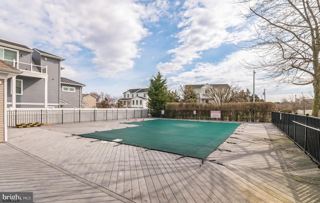 community pool featuring a residential view, a patio, and fence