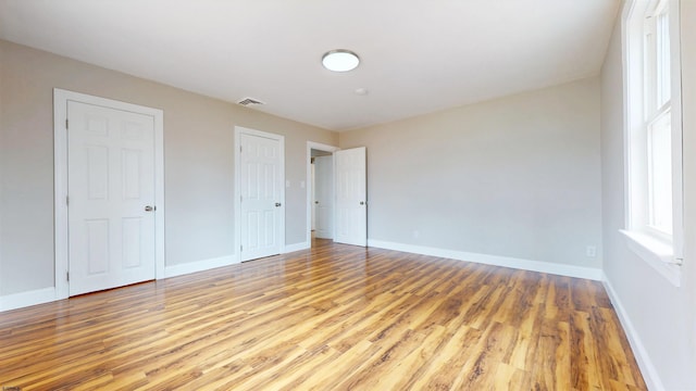 unfurnished bedroom with baseboards and light wood finished floors