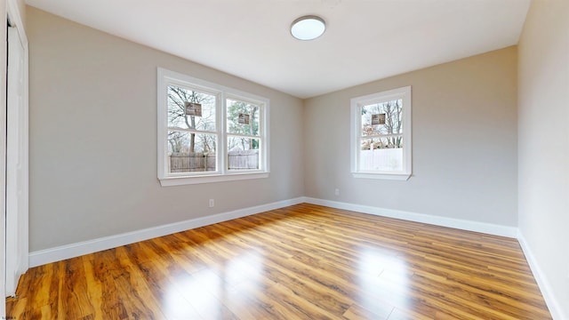 unfurnished room with baseboards and wood finished floors