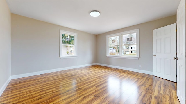 unfurnished room with baseboards and wood finished floors