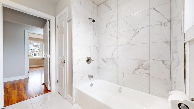 bathroom with shower / bathing tub combination, baseboards, and marble finish floor