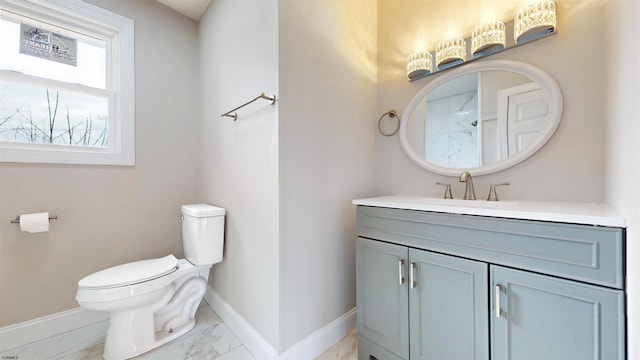 bathroom featuring vanity, toilet, baseboards, and marble finish floor