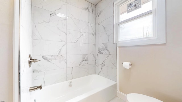 bathroom with toilet, shower / bath combination, and baseboards