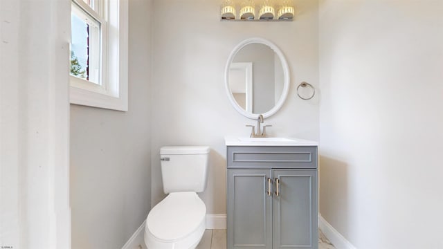 bathroom with vanity, toilet, and baseboards