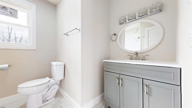 bathroom with baseboards, toilet, marble finish floor, and vanity