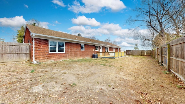 back of house with brick siding, cooling unit, a wooden deck, and a fenced backyard