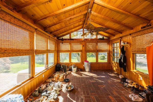 unfurnished sunroom featuring wooden ceiling, plenty of natural light, a ceiling fan, and vaulted ceiling with beams