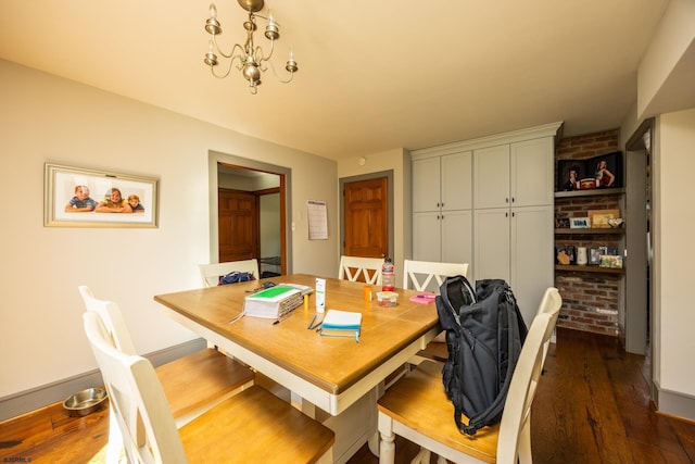 dining room with dark wood finished floors, baseboards, brick wall, and a chandelier