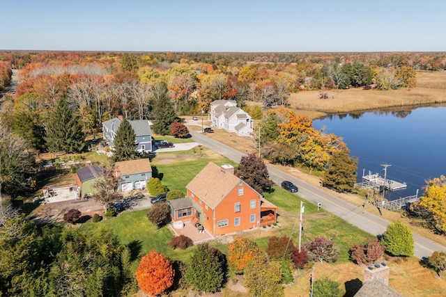 drone / aerial view featuring a wooded view and a water view