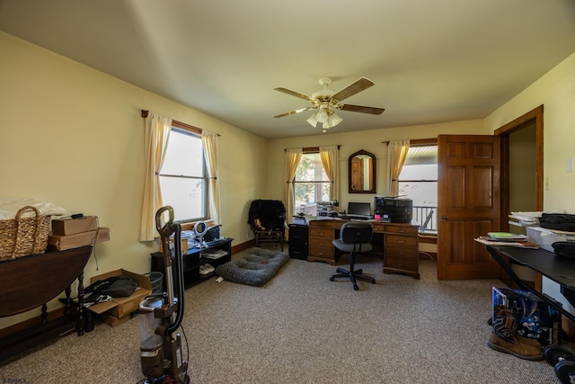 carpeted home office with a ceiling fan