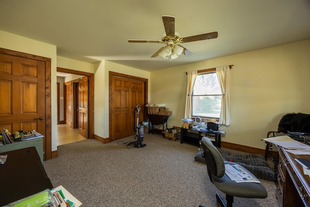 home office with baseboards, a ceiling fan, and carpet