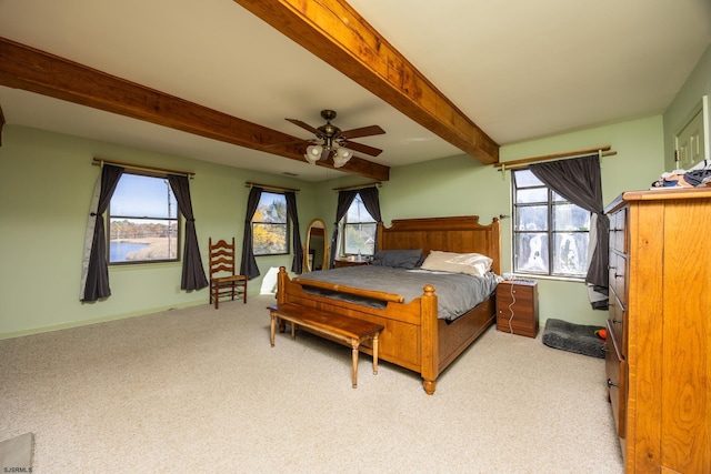 bedroom with beamed ceiling, light carpet, baseboards, and a ceiling fan