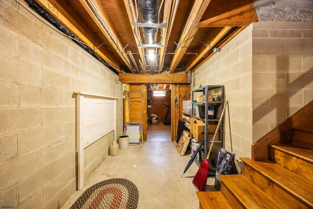 unfinished below grade area featuring stairs and concrete block wall