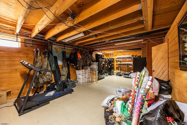 below grade area featuring tile patterned floors and wood walls