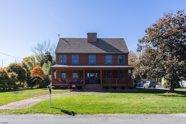 view of front of house featuring a front lawn, covered porch, and a chimney