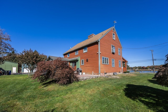 view of property exterior featuring a yard, a chimney, and a shingled roof