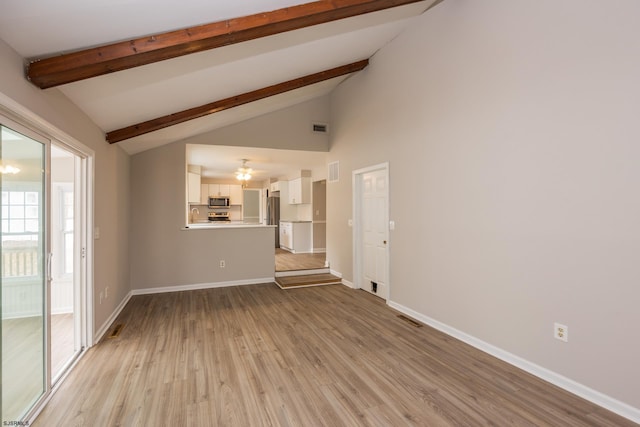 unfurnished living room with visible vents, baseboards, light wood-type flooring, and beam ceiling