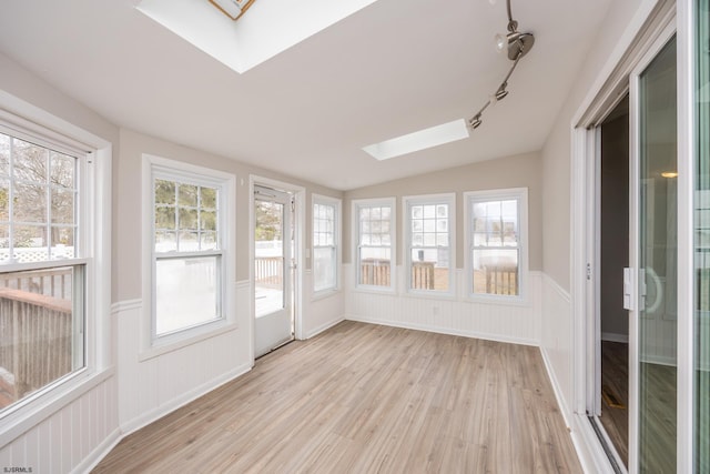 unfurnished sunroom featuring lofted ceiling with skylight and a healthy amount of sunlight