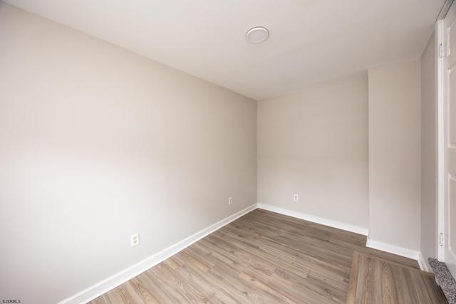 empty room with light wood-type flooring and baseboards