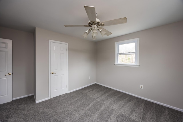 unfurnished bedroom with baseboards, a ceiling fan, and dark carpet