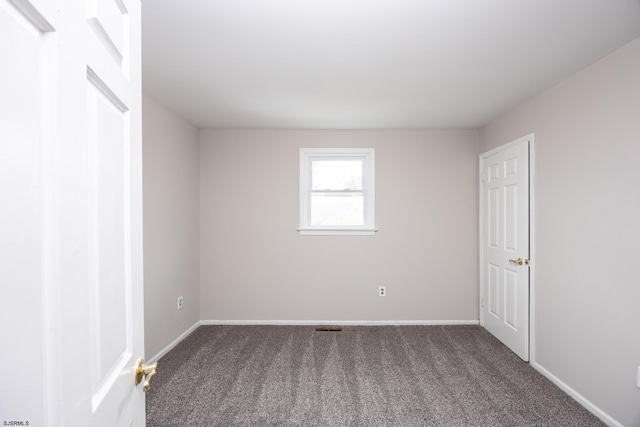 unfurnished room with carpet and baseboards