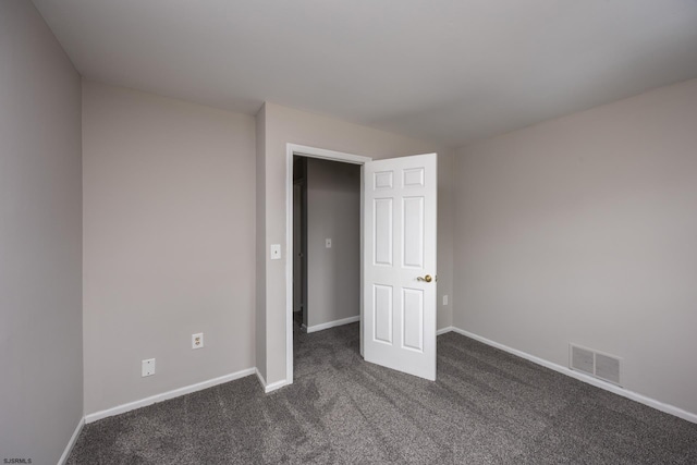 unfurnished bedroom with visible vents, baseboards, and dark colored carpet